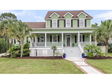 Charming two-story home featuring a spacious porch, well-manicured lawn, and lush tropical landscaping at 591 Two Mile, Johns Island, SC 29455