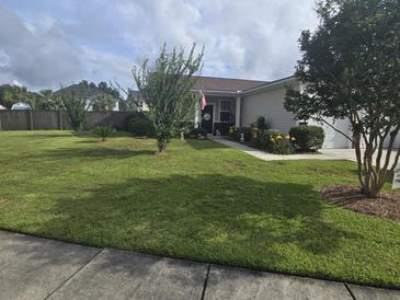 Charming single-story home with well-manicured lawn, flowerbeds, and walkway leading to the front door at 605 Grassy Hill Rd, Summerville, SC 29483