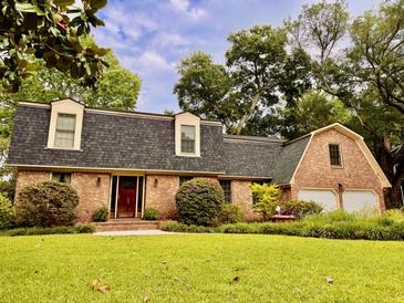 Charming brick home featuring a well-maintained lawn, mature landscaping, and inviting curb appeal at 8 Brisbane Dr, Charleston, SC 29407