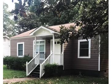 Charming single-story home with brown siding, white trim, and a cozy front porch with a white railing at 8930 Selah St, North Charleston, SC 29406