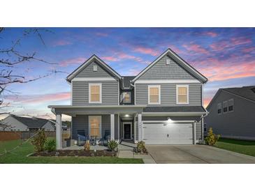 Charming two-story home with a covered front porch and attached garage, perfect for Gathering living at 107 Cotton Blossom Way, Summerville, SC 29485