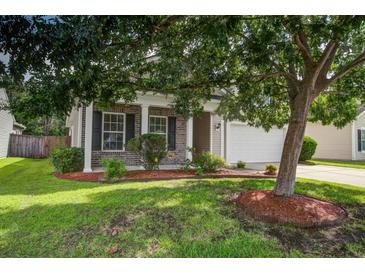 Charming brick-accented home with a well-manicured lawn and mature tree providing shade at 112 Mayfield Dr, Goose Creek, SC 29445