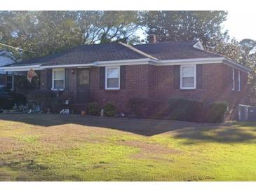 Cozy brick home featuring a well-maintained lawn, trimmed shrubs, and a welcoming front entrance at 1237 Fort Dr, Hanahan, SC 29410