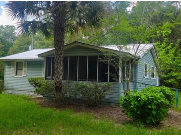 Charming home featuring a screened porch and lush landscaping at 126 Rattlensnake Trl, Walterboro, SC 29488