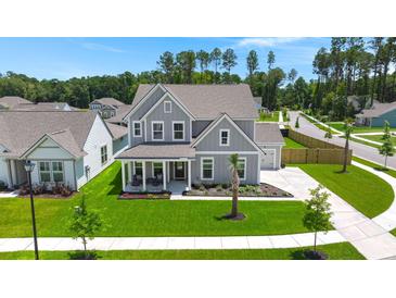 Beautiful two-story home with a manicured lawn, a charming front porch, and a well-kept garden at 1950 Parish House Cir, Johns Island, SC 29455