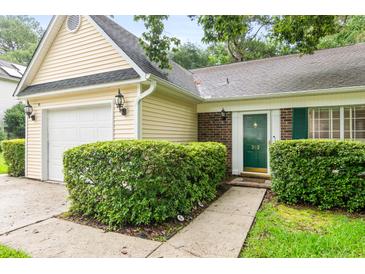 Charming home featuring a well-manicured lawn, a garage, and a welcoming front door with green shutters at 202 Chandler Dr, Ladson, SC 29456