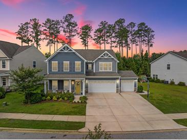 Charming two-story home with a three car garage, landscaped yard and inviting front porch at 443 Coopers Hawk Dr, Summerville, SC 29483