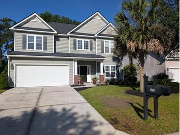 Charming two-story home boasts a manicured lawn, two car garage, and appealing architectural details at 5256 Mulholland Dr, Summerville, SC 29485