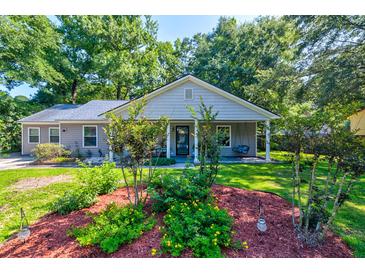 Charming single-story home with a manicured lawn and inviting front porch swing at 102 Cottonwood Dr, Summerville, SC 29483