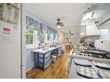 Functional kitchen with a gas range, blue-trimmed windows, and vinyl flooring at 145 Ravenell Dr, Saint Stephen, SC 29479