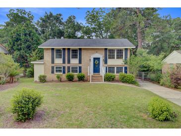 Charming two-story brick home with a lush lawn, blue shutters and door, and well-maintained landscaping at 1525 Westmoreland Ave, Charleston, SC 29412