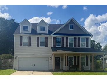 Charming two-story home with front porch, garage, shuttered windows and landscaped front yard at 158 Balsam Cir, Summerville, SC 29485
