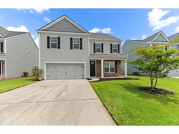 Charming two-story home with a manicured lawn, stone accents, and an attached two-car garage at 158 Netherfield Dr, Summerville, SC 29486