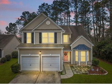Charming two-story home with a manicured lawn, two-car garage, and welcoming pink front door at 2004 Hammond Dr, Mount Pleasant, SC 29466