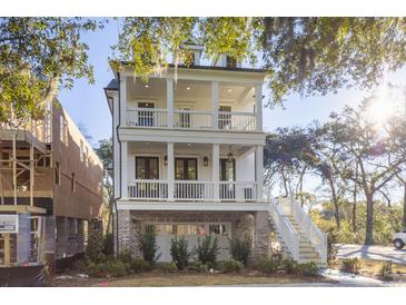 Two-story home with double balconies, white columns, brick foundation and staircase to main level at 2356 Hut Creek Rd, Johns Island, SC 29455