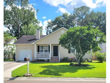 Charming single-story home featuring a well-manicured lawn and a lovely front porch and attached garage at 4457 Rice Mill Dr, North Charleston, SC 29420