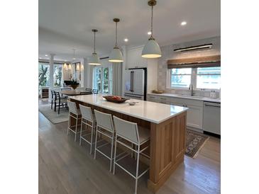 Bright kitchen features a large island with seating, pendant lighting, and stainless steel appliances at 578 Island Walk East, Mount Pleasant, SC 29464