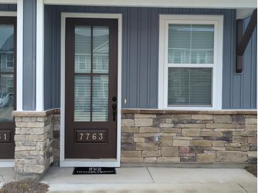 Charming entryway featuring a brown front door, stone accents, and a small window at 7763 Park Gate Dr, North Charleston, SC 29418