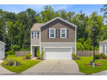Charming two-story home featuring a neat lawn, a two-car garage, and lovely curb appeal at 9808 Wooden Pestle Way, Ladson, SC 29456