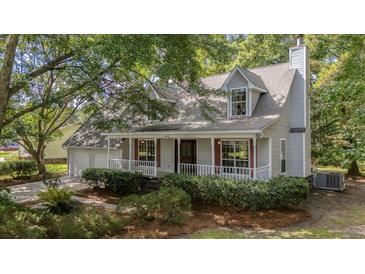 Charming home with a cozy front porch, red shutters, white rails, and beautifully landscaped yard at 202 Woodbridge Dr, Summerville, SC 29486