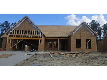 Unfinished exterior showcasing the structure, roof, and garage of a single-story home with a concrete driveway at 232 Huguenot Trl, Huger, SC 29450