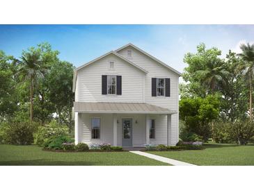 Charming two-story home with white siding, a covered porch, and lush landscaping at 304 Archar St, Summerville, SC 29486