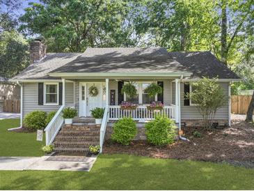 Charming single-story home with inviting front porch, brick stairs, lush landscaping, and mature trees at 1337 Old Fort Rd, Moncks Corner, SC 29461