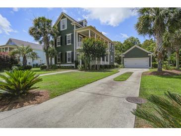 Inviting two-story home featuring a spacious driveway, lush landscaping, and a charming garage with matching paint at 136 Heart Pine Cir, Summerville, SC 29485