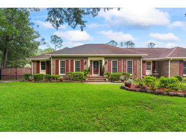 Charming brick home with manicured lawn, red shutters, and mature landscaping provides curb appeal at 1551 Hutton Pl, Charleston, SC 29407