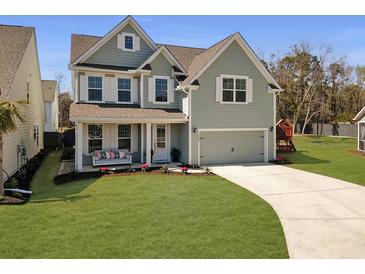 Charming two-story home featuring a cozy front porch with a swing and a well-manicured lawn at 2889 Backman St, Mount Pleasant, SC 29466