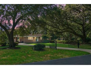 Charming brick home with lush front lawn, mature trees, and gated driveway at 4428 Maple Ridge Rd, Walterboro, SC 29488