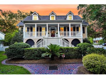 Charming two-story home with a inviting front porch, manicured landscaping and a brick path at 512 Whilden St, Mount Pleasant, SC 29464