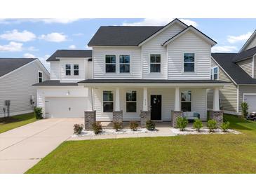 Charming two-story home featuring a white exterior, black roof, covered front porch, and well-manicured lawn at 513 Richfield Way, Summerville, SC 29486