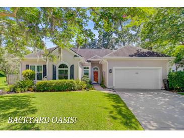 Charming single-story home with manicured lawn, beautiful landscaping, and a two-car garage at 5406 E Crosland Ct, North Charleston, SC 29420