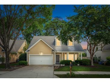 Charming home with a well-manicured lawn, mature trees, and a welcoming two-car garage at 708 Lawton Harbor Dr, Charleston, SC 29412