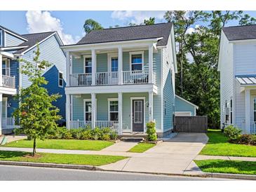 Charming two-story home with a inviting double porch, lush landscaping, and private driveway at 109 W Respite Ln, Summerville, SC 29483