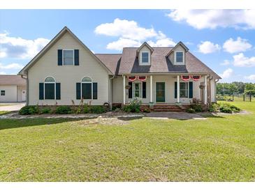 Charming two-story home with a covered front porch and beautifully landscaped front yard at 1111 Sandy Springs Circle, Walterboro, SC 29488