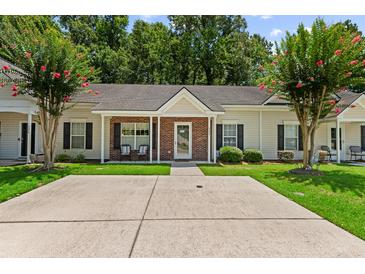 Charming single-story home with a brick and siding facade, well-manicured lawn, and flowering trees at 122 Stewart Pl, Summerville, SC 29485