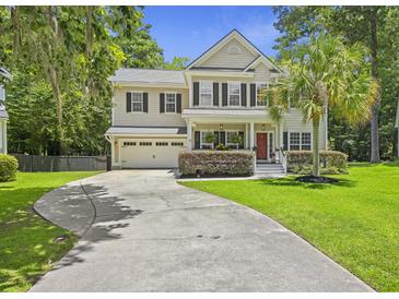 Charming two-story home with a well-manicured lawn, long driveway, attached garage and a delightful red front door at 1228 Walleye Cor, Charleston, SC 29414