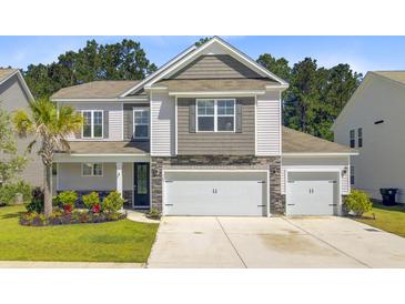 Charming two-story home with a landscaped yard and a three car attached garage at 142 Airy Dr, Summerville, SC 29486