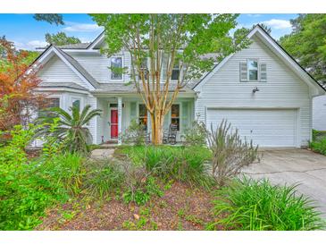 Charming two-story home featuring a bright red front door, mature landscaping, and an attached two car garage at 1972 Gray Battery Ct, Mount Pleasant, SC 29464
