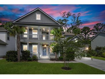 Charming two-story home with a double porch, mature trees, and a well-manicured lawn at dusk at 2331 Brinkley Rd, Johns Island, SC 29455
