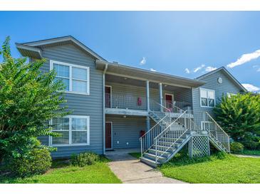 Well-maintained two-story condo building with gray siding, metal stairs, and green lawn under a clear blue sky at 2601 Riverridge Ct # A, Moncks Corner, SC 29461