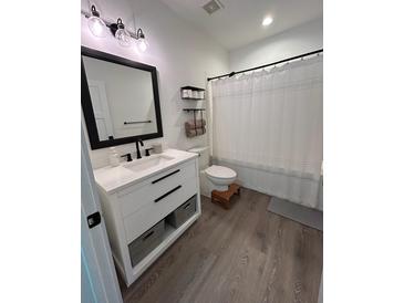 Modern bathroom featuring a white vanity with black accents and a shower with a white curtain at 400 Bucksley Ln # 301, Charleston, SC 29492