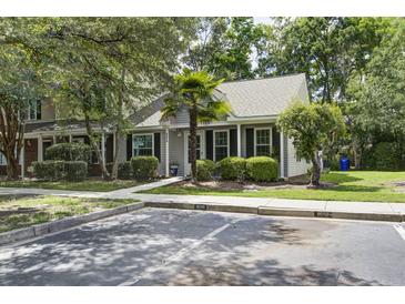 Charming home with a well-maintained lawn, mature trees, and dedicated parking spots at 8059 Shadow Oak Dr, North Charleston, SC 29406