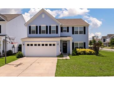 Charming blue two-story home with a well-manicured lawn and a two-car garage on a sunny day at 109 Goose Rd, Summerville, SC 29483
