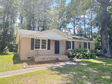 Charming single-story brick home featuring classic design, black shutters, and a well-manicured front yard at 114 Madison St, Walterboro, SC 29488