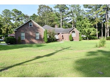 Charming brick home with manicured lawn and mature trees, offering classic curb appeal and a welcoming atmosphere at 1457 Green Pond Hwy, Walterboro, SC 29488
