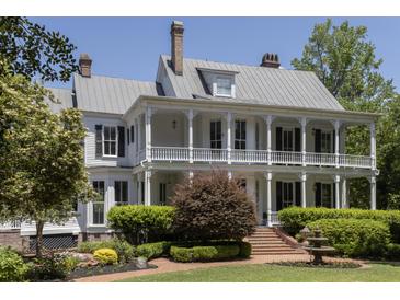 Two-story home featuring a charming wrap-around porch, lush landscaping, and a beautiful fountain at 208 Sumter Ave, Summerville, SC 29483