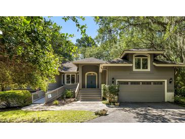 Charming home featuring a lovely gray exterior, welcoming stairs, mature trees, and an attached garage at 2938 Old Drake Dr, Seabrook Island, SC 29455
